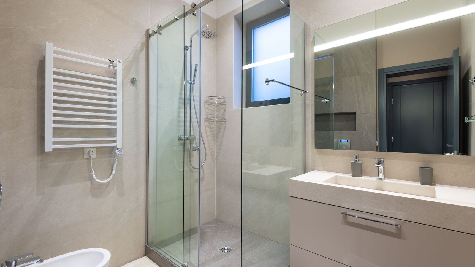 Douche à l'italienne avec paroi vitrée et carrelage clair