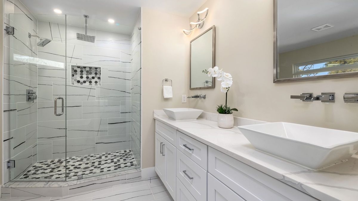 Salle de bains au carrelage clair avec douche à l'italienne